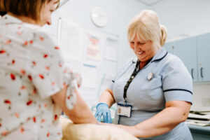 smiling nurse running tests on a woman