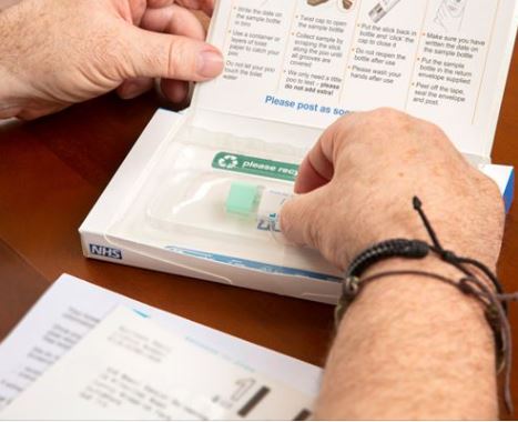 Image shows a bowel cancer screening kit