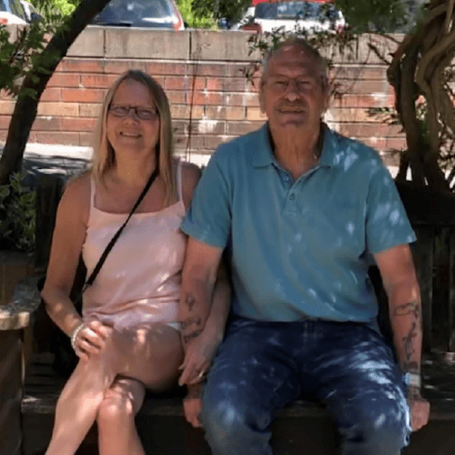 Christine and Danny, two lung health check participants, sitting on a bench outside.