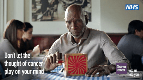 Image of a man playing with a jack in a box toy. The images also says 'don't let the thought of cancer play on your mind'.