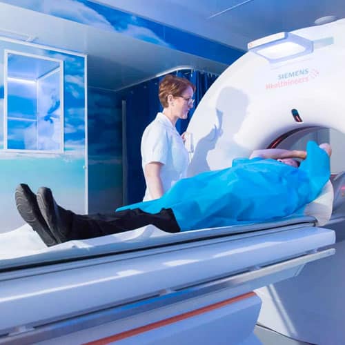 picture of a person entering the scanner with a nurse stood beside