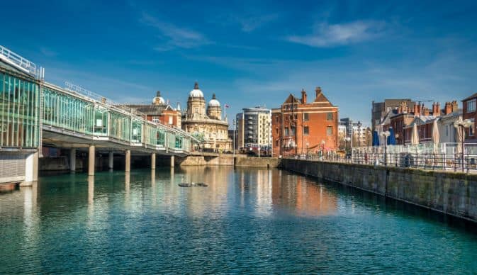 pictures of a city centre buildings with the river and riverbank in the forefront