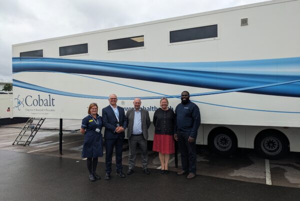 Lung health check mobile unit and staff posing in front of it